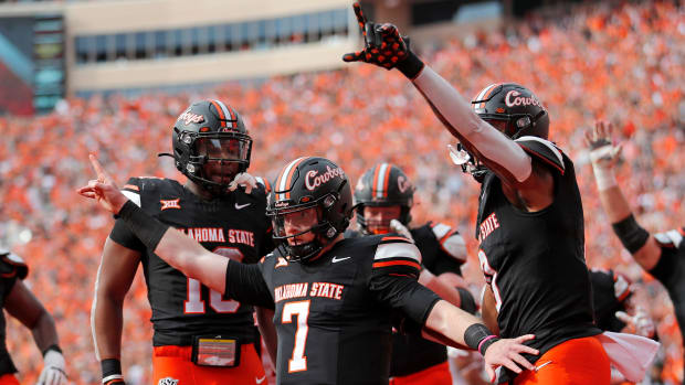 Oklahoma State's Alan Bowman (7) celebrates his touchdown with Ollie Gordon II (0) and Rashod Owens (10) in the first half during a Bedlam college football game between the Oklahoma State University Cowboys (OSU) and the University of Oklahoma Sooners (OU) at Boone Pickens Stadium in Stillwater, Okla., Saturday, Nov. 4, 2023.